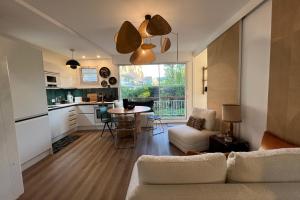 a living room with a couch and a table and a kitchen at Family apartment near the sea of Houlgate in Houlgate