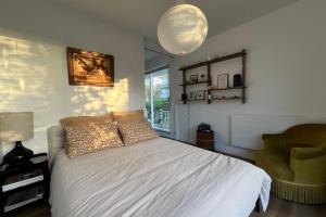 a bedroom with a white bed and a chair at Family apartment near the sea of Houlgate in Houlgate +5 photos