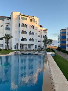 a building with a swimming pool in front of a building at Puesta Del Sol in Asilah