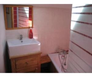 Un baño con un lavabo blanco y un espejo. en Chalet - Les 3 vallées, en La Combe