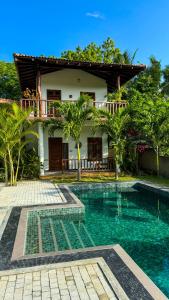 a villa with a swimming pool in front of a house at The lookout lodge in Tangalle +21 photos
