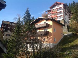 ein Apartmenthaus an der Seite eines Hügels in der Unterkunft Chalet Tannenrain & Casa Alba in Arosa