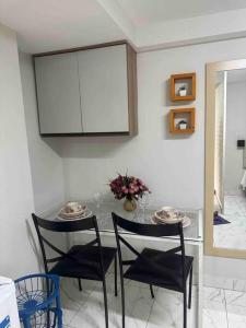 a dining room with a table and two chairs at kitnet 13 central com ar tv smart completa in Montes Claros +7 photos