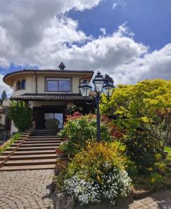 Una casa con una farola y algunas flores. en B&B Villa La Castagnola, en Rocca di Papa