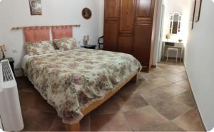 Un dormitorio con una cama con una colcha floral. en B&B Villa La Castagnola, en Rocca di Papa
