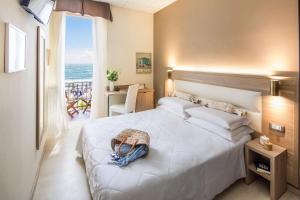 a bedroom with a bed with a view of the ocean at Hotel Tina in Diano Marina +84 photos