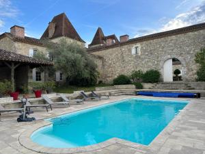 a swimming pool in front of a building with a house at Chateau de Mazelieres in Espiens