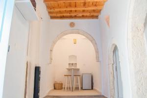 an archway in a white building with two stools at Villa Bahia Djerba in Houmt Souk