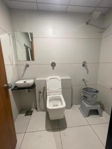 a small bathroom with a toilet and a sink at Hotel Royal Orbit in Rajkot