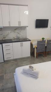 a kitchen with white cabinets and a table with a towel at Miri's Villa in Sarandë