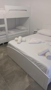 two beds with towels on top of them in a room at Miri's Villa in Sarandë +7 photos