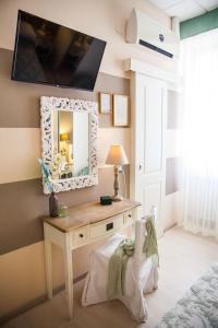 a bedroom with a dressing table and a mirror at Hotel Tina in Diano Marina