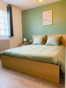 - une chambre avec un grand lit et un cadre en bois dans l'établissement Maison proche de la Cité avec jardin, à Carcassonne