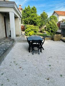 une table noire et deux chaises dans une cour dans l'établissement Maison proche de la Cité avec jardin, à Carcassonne 6 autres photos