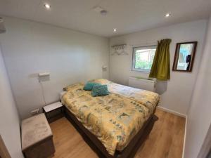 ein Schlafzimmer mit einem großen Bett in einem Zimmer in der Unterkunft Comfortabele houten Chalet bij de Veluwe in Epe + 11 Fotos