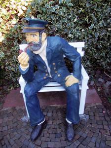 a statue of a man sitting on a bench at Sahneschnittchen in Hage
