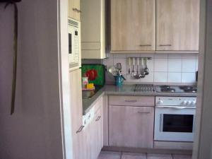 a kitchen with white cabinets and a stove top oven at Sahneschnittchen in Hage