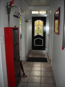 a hallway with a black door with a window at Sahneschnittchen in Hage