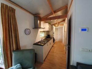 eine Küche mit einem Steinfernsehsender, einer Stesterin, einer Stesterin, einer Stesterin, einer Stesterin und einer Stesterin in der Unterkunft Comfortabele houten Chalet bij de Veluwe in Epe