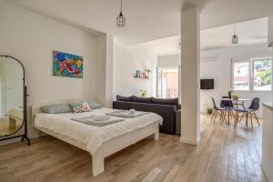 - un salon blanc avec un lit et un canapé dans l'établissement Magi-Family Rooftop Apartment Budva, à Budva