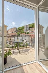 une vue d'un balcon avec une table et des chaises dans l'établissement Magi-Family Rooftop Apartment Budva, à Budva