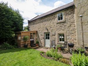 a stone house with a grill in the yard at Dale End Farm Cottage in Bakewell