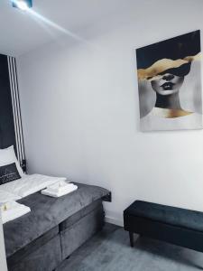 a bedroom with a bed and a picture of a woman at Apartament Sztuk Pięknych 14 in Piła