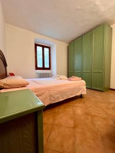 a bedroom with a large bed with green cabinets at Amazing castle house in Mombaldone