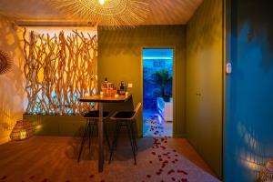 a dining room with a table and two stools at OIQIA • Bali in Narbonne