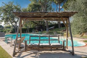 un columpio frente a una piscina en Villa Mazzini by Mmega, en Lucignano