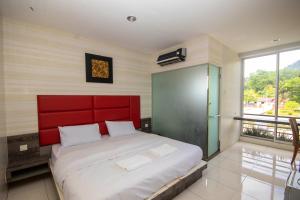 Rúm í herbergi á JQ Happy Lumut Hotel