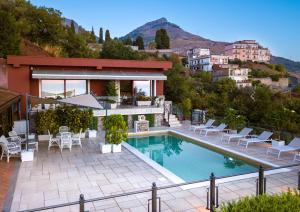 a villa with a swimming pool and chairs and a house at Villa del Sole in Taormina