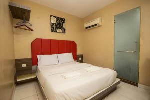 Rúm í herbergi á JQ Happy Lumut Hotel