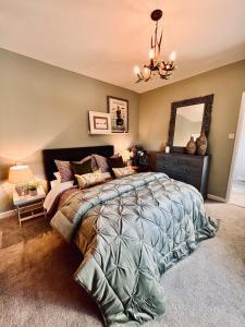 a bedroom with a large bed and a chandelier at 4 - Walkers Cottage - Scandinavian BBQ hut -Open fire in Pont Sticill