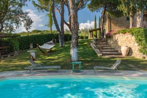 una piscina con 2 sillas y un patio en Villa Mazzini by Mmega, en Lucignano
