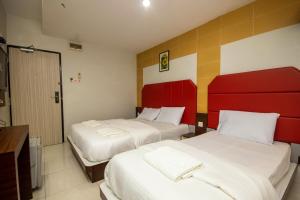 Rúm í herbergi á JQ Happy Lumut Hotel