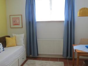 a living room with blue curtains and a couch at Rosa Canina W2 in Kellenhusen
