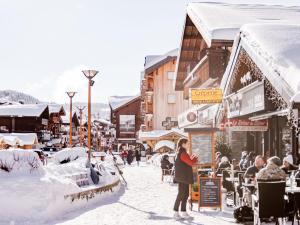 a woman standing on a street covered in snow at Appartement au centre Les Gets, 3 étoiles, 3 pers, proche télécabines et école de ski - FR-1-671-6 in Les Gets