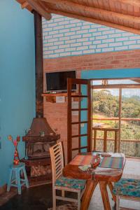 a dining room with a table and a fireplace at Pousada Canto dos Pássaros in Santo Antônio do Pinhal
