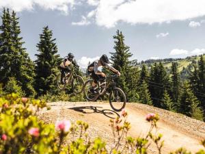 two people riding bikes on a dirt trail at Charmant 2 pièces au cœur des Gets, proche télécabines, balcon, Wi-Fi, garage, animaux bienvenus - FR-1-671-137 in Les Gets