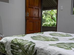 a bedroom with a bed with a green and white blanket at Amapondo in Port St. Johns