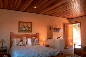 a bedroom with a bed and a wooden ceiling at Pousada Canto dos Pássaros in Santo Antônio do Pinhal +13 photos