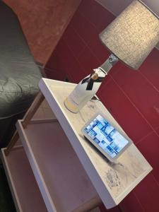 Atena B&B APARTMENTS Imperial في San Silvestro: طاولة عليها مصباح وهاتف محمول +15 صورة