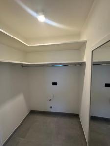an empty room with a white wall and a mirror at Casa Mimosa in Ischia +1 photo