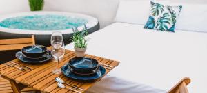 a table with two chairs and a bathtub at La Calita Escondida - Jacuzzi y Cocina en Terraza Privada - Piscina y Parking Gratis in Chiclana de la Frontera