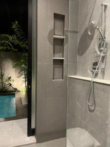 a bathroom with a shower with a glass door at Brand New! Private Room near Canggu Surfing Beaches in Canggu