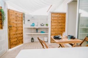a dining room with a table and a wooden door at La Calita Escondida - Jacuzzi y Cocina en Terraza Privada - Piscina y Parking Gratis in Chiclana de la Frontera