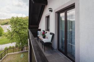 a balcony with chairs and a table with flowers on it at Apartman Malnar Lokve in Lokve