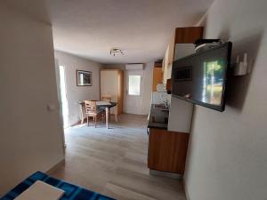 a living room with a flat screen tv on a wall at Apartman-Cottage Grgec in Jelsa +15 photos