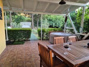 a wooden table with two glasses of wine on a patio at Apartman-Cottage Grgec in Jelsa